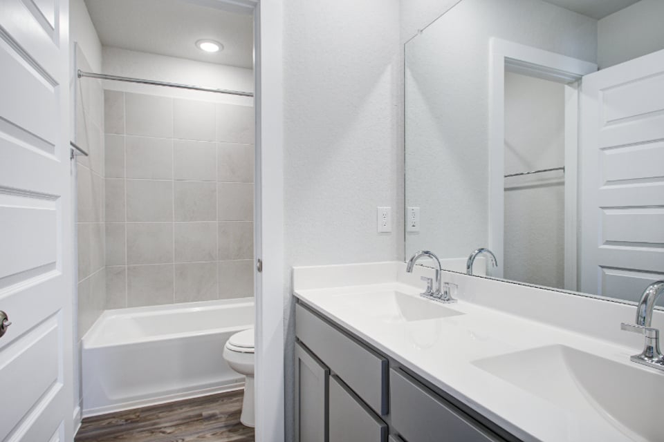A bathroom with a tub sink and toilet.