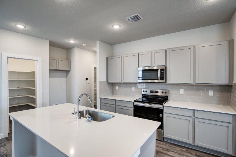 A kitchen with white cabinets.