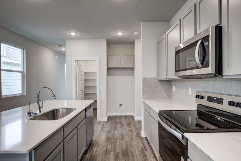 A kitchen with white cabinets.