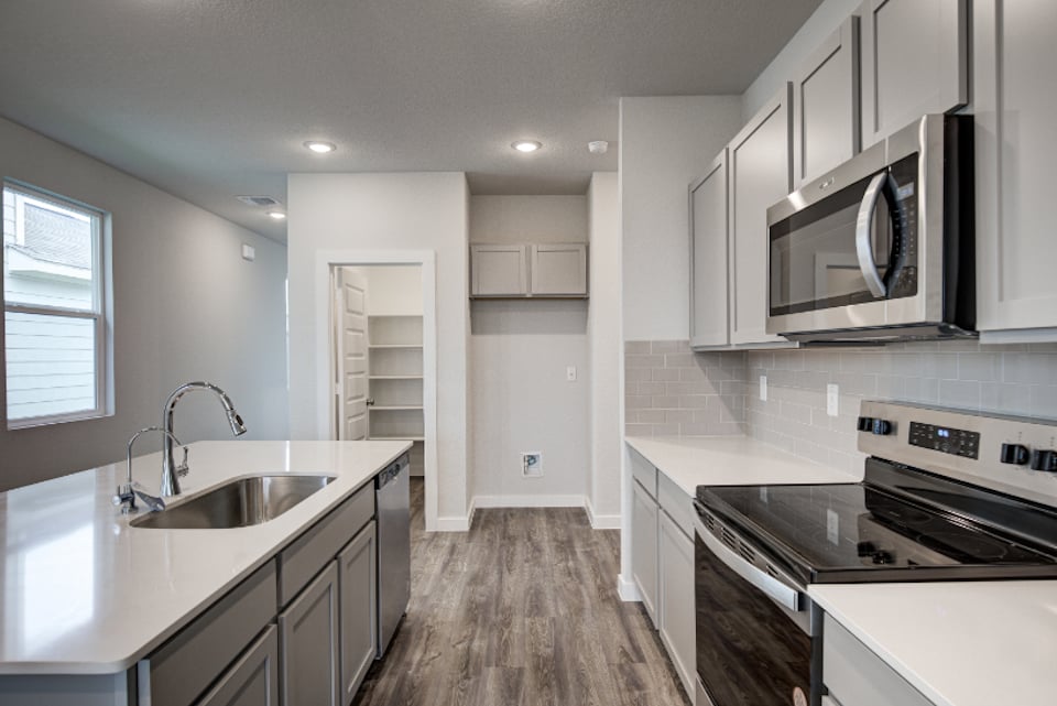 A kitchen with white cabinets.
