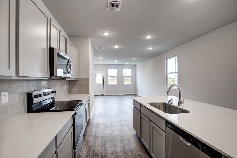 A kitchen with white cabinets.