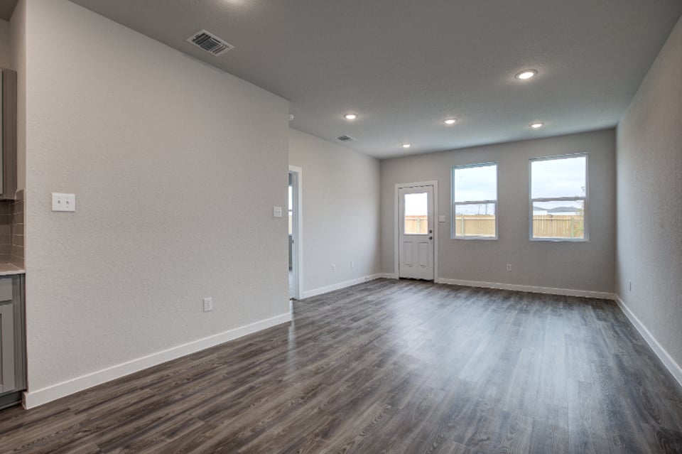 A room with a wood floor and windows.