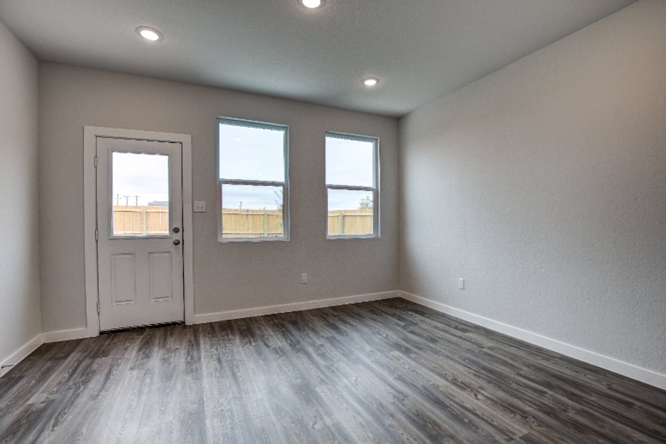 A room with windows and a wood floor.