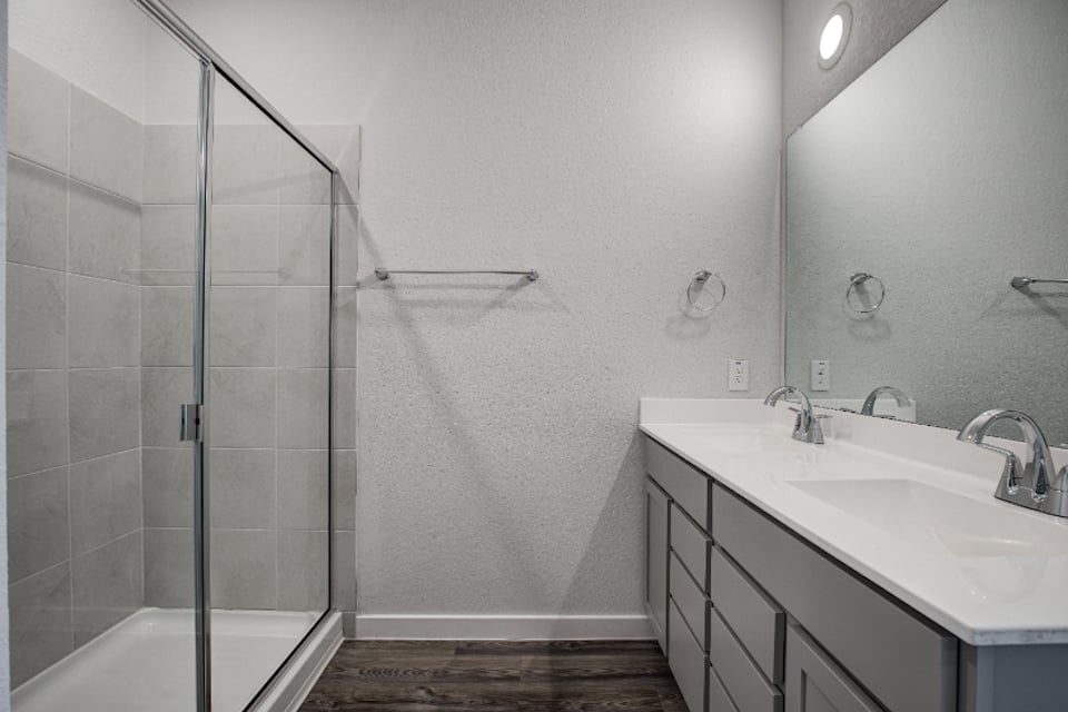 A bathroom with a shower and sink.