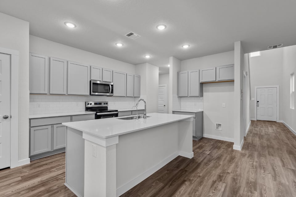 A kitchen with white cabinets.