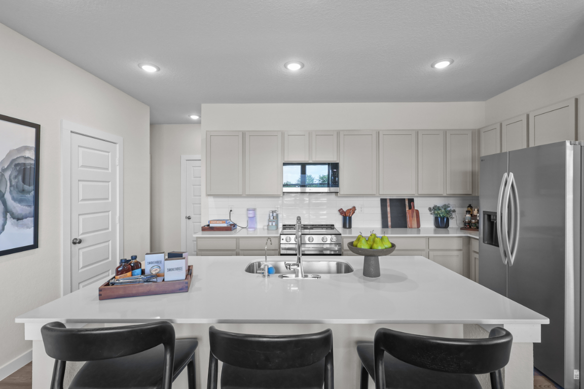 A kitchen with white cabinets.