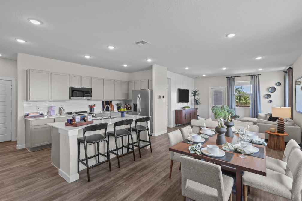 A kitchen with a dining table and chairs.