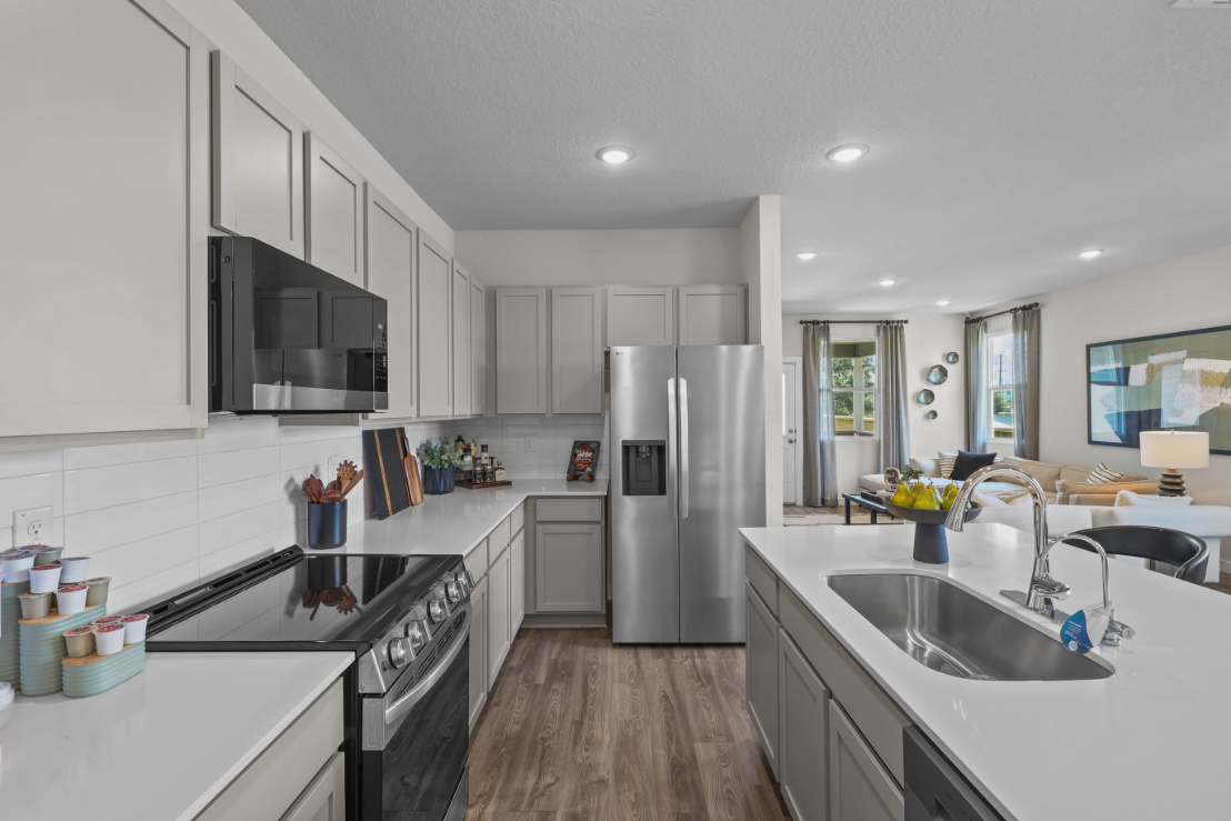A kitchen with white cabinets.