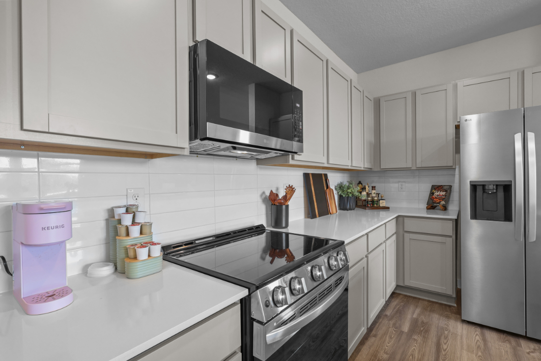 A kitchen with white cabinets.