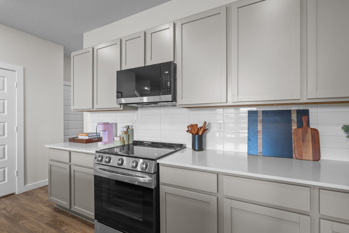 A kitchen with white cabinets.