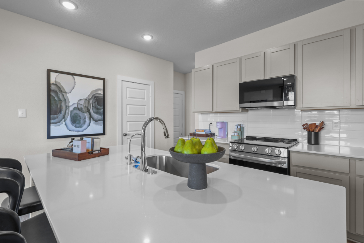 A kitchen with white cabinets.