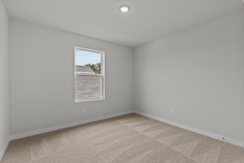 A room with a window and a rug.