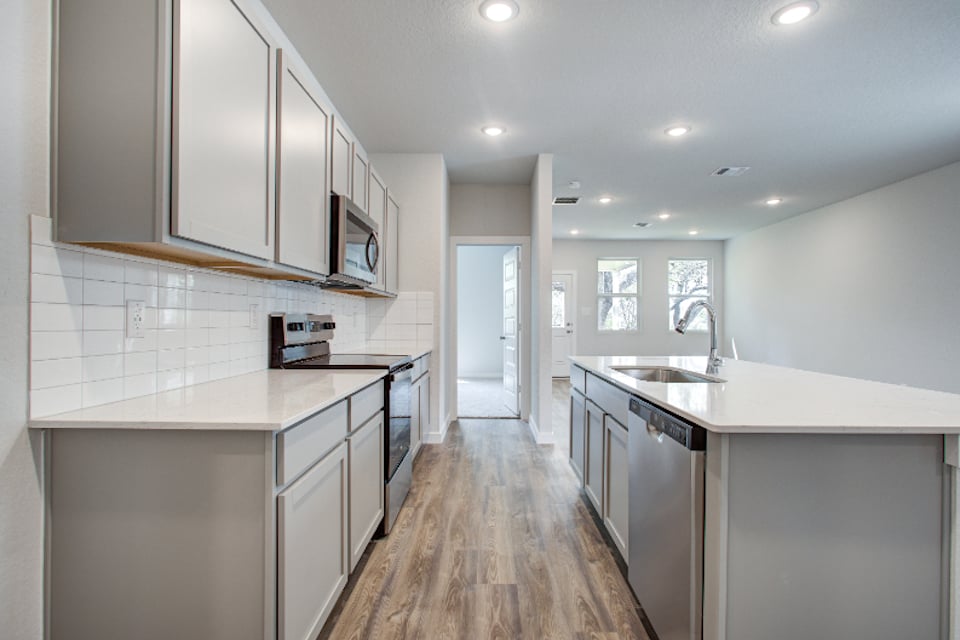 A kitchen with white cabinets.