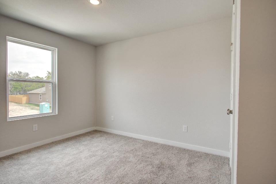 A room with a carpet and a window.