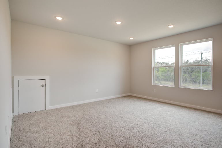 A room with a carpet and windows.