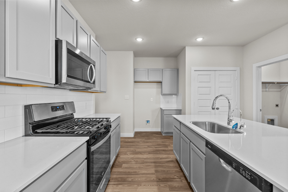 A kitchen with white cabinets.