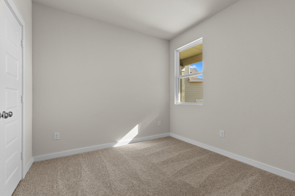 A room with a window and carpet.