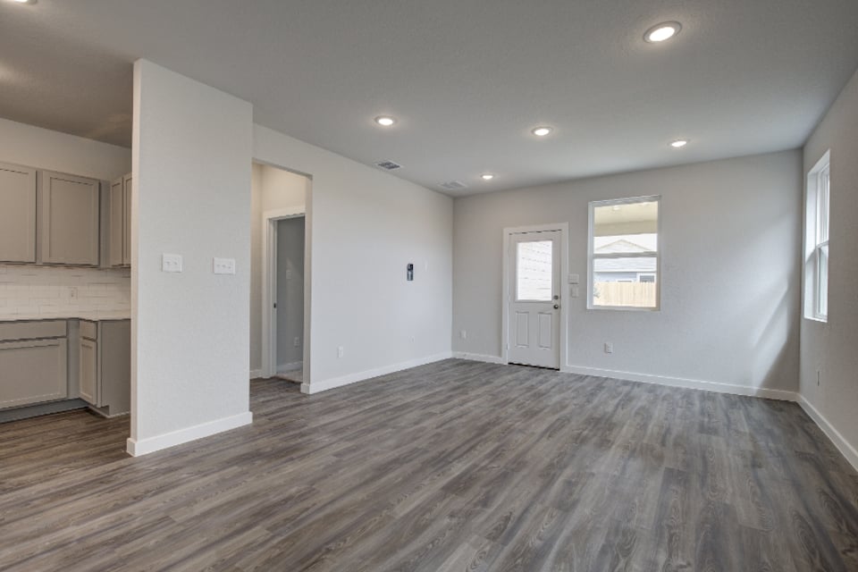 A room with white walls and wood floors.
