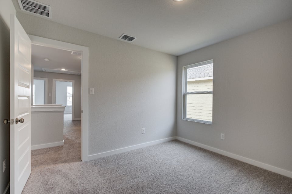 A room with a carpet and a window.