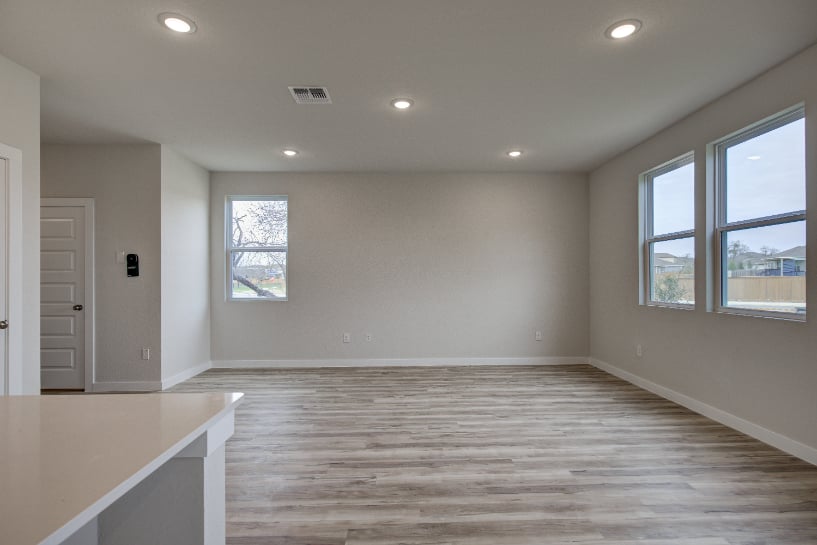 A room with a wood floor and windows.