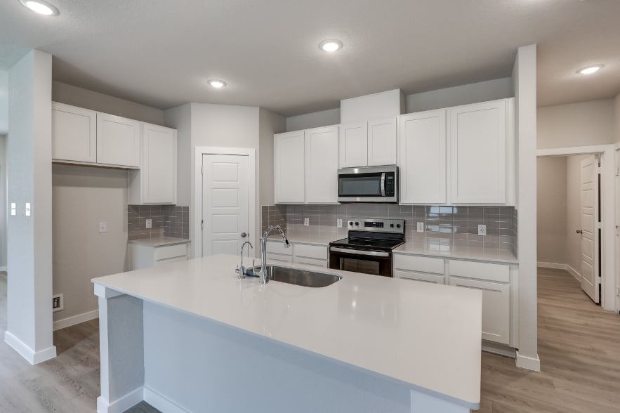 A kitchen with white cabinets.