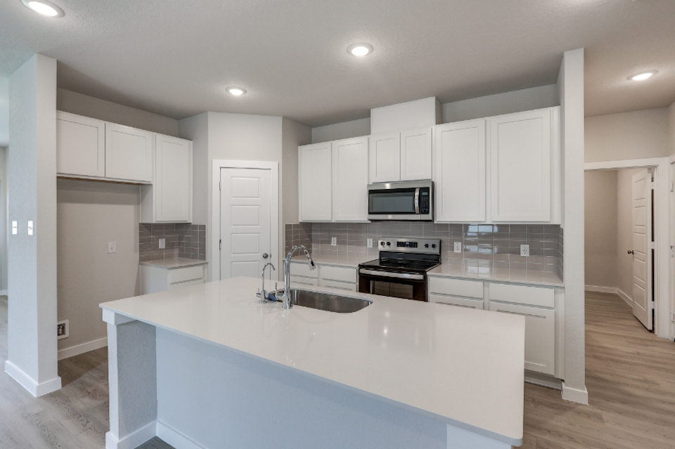 A kitchen with white cabinets.