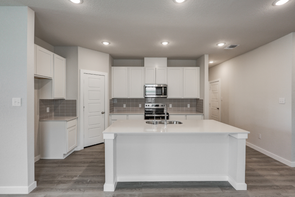 A kitchen with white cabinets.