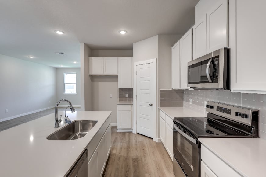 A kitchen with white cabinets.