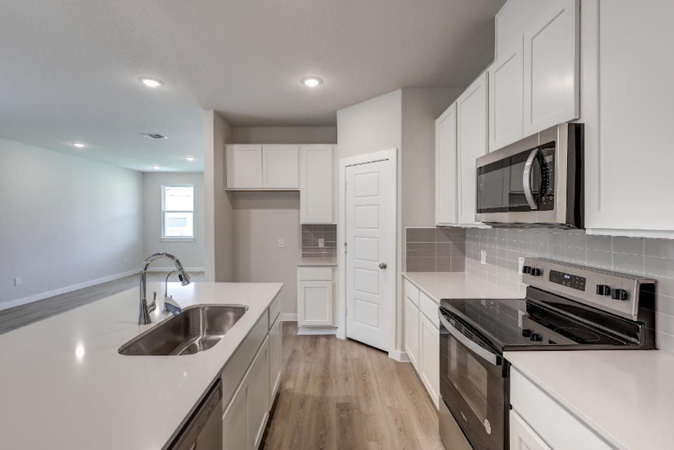 A kitchen with white cabinets.