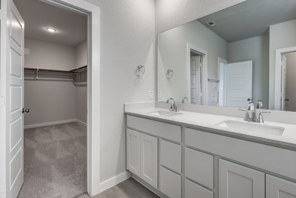 A bathroom with white cabinets.