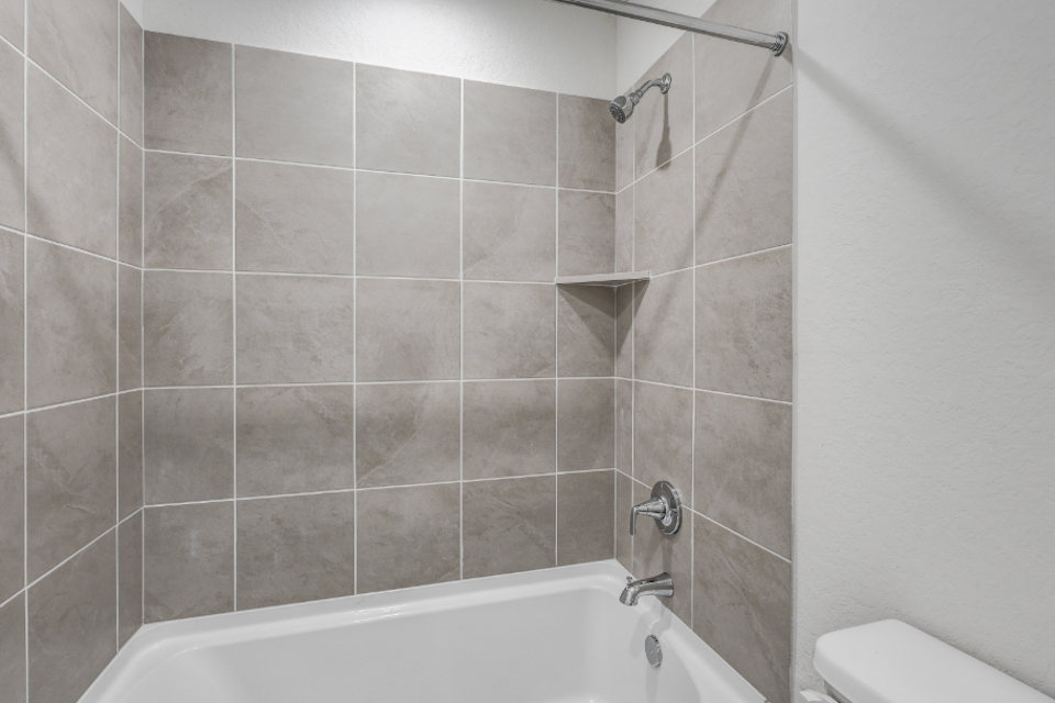 A bathroom with a bathtub and toilet.