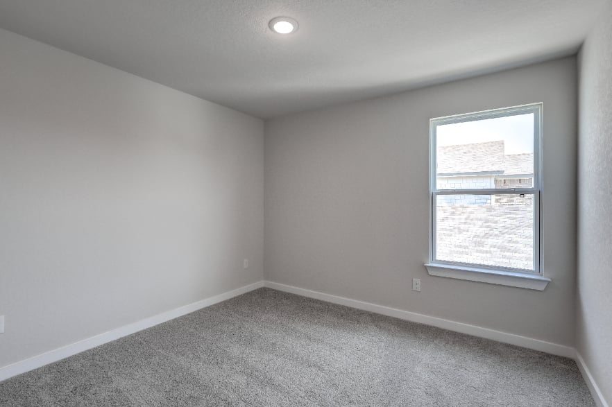 A room with a window and a carpet.