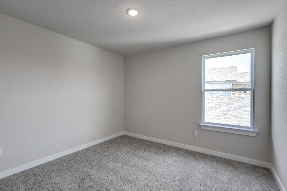 A room with a window and a carpet.