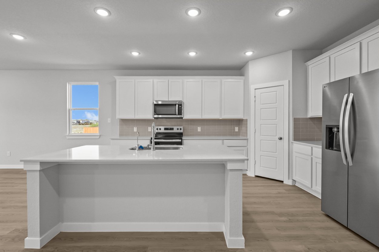 A kitchen with white cabinets.