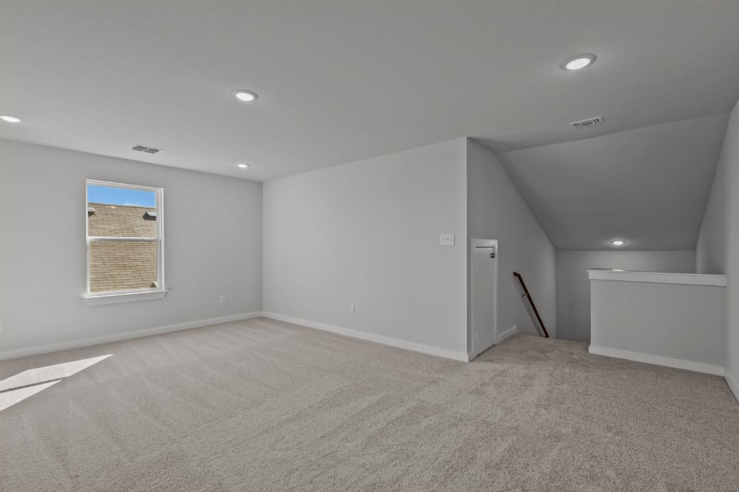 A room with a carpet and a window.