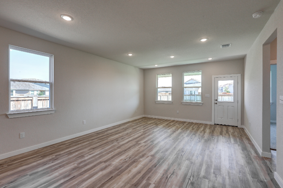 A room with a wood floor and windows.