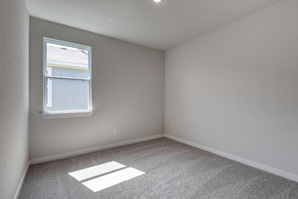A room with a window and carpet.