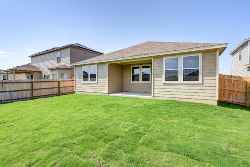 A house with a fence and grass.