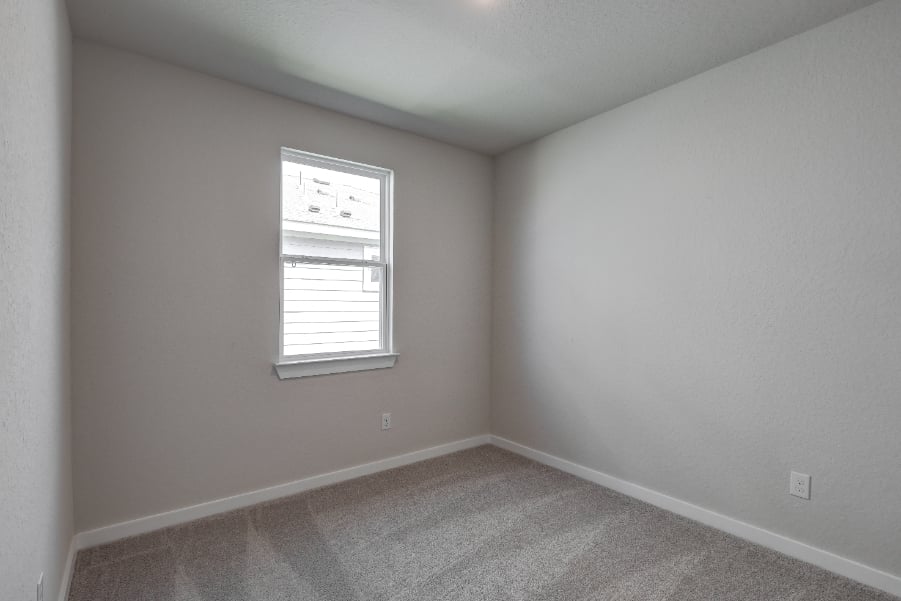 A room with a window and a carpet.