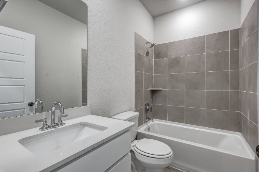 A bathroom with a sink toilet and bathtub.