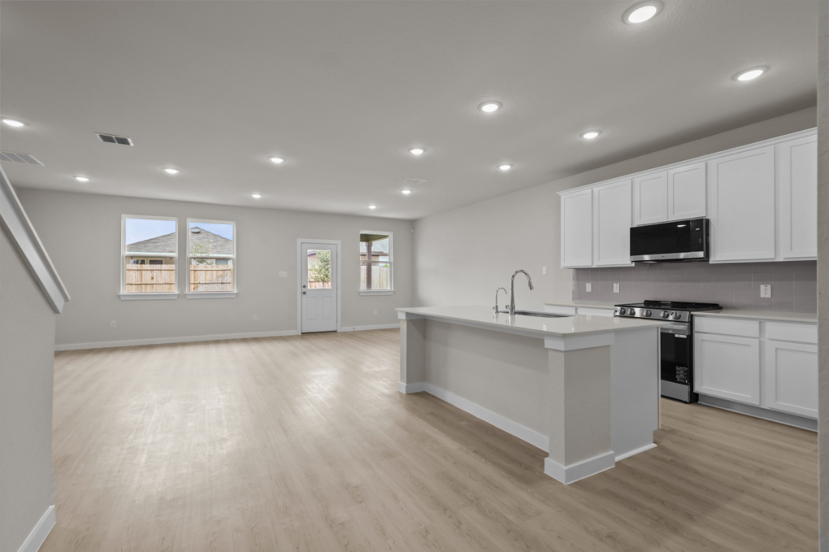 A kitchen with white cabinets.