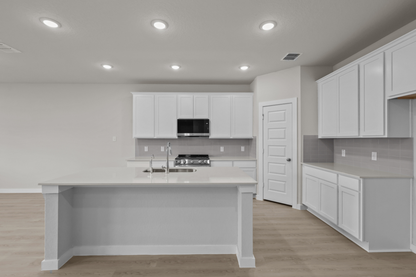 A kitchen with white cabinets.