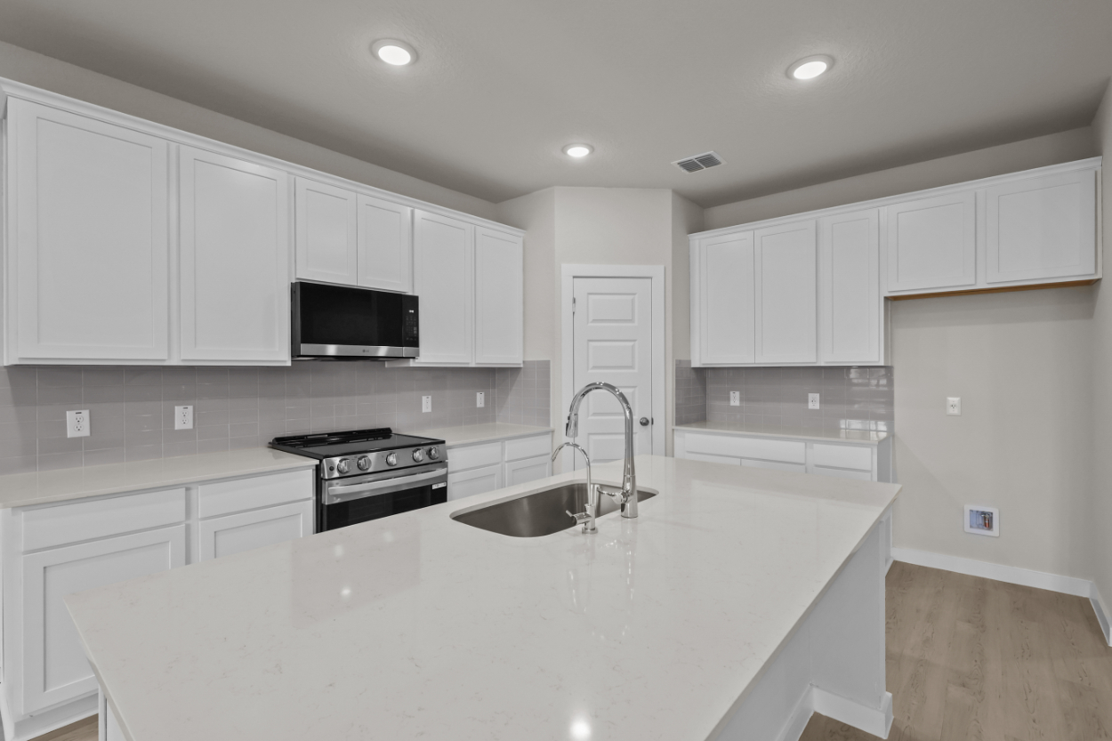 A kitchen with white cabinets.