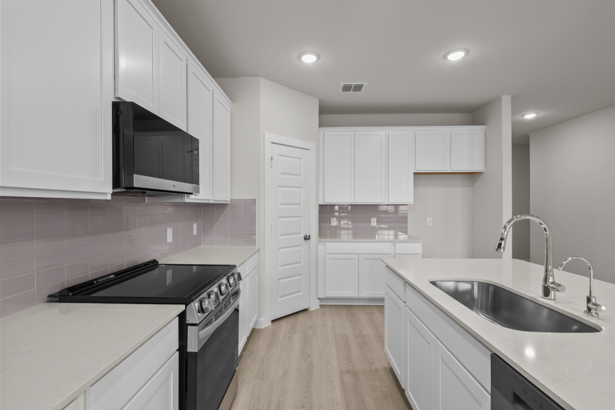 A kitchen with white cabinets.