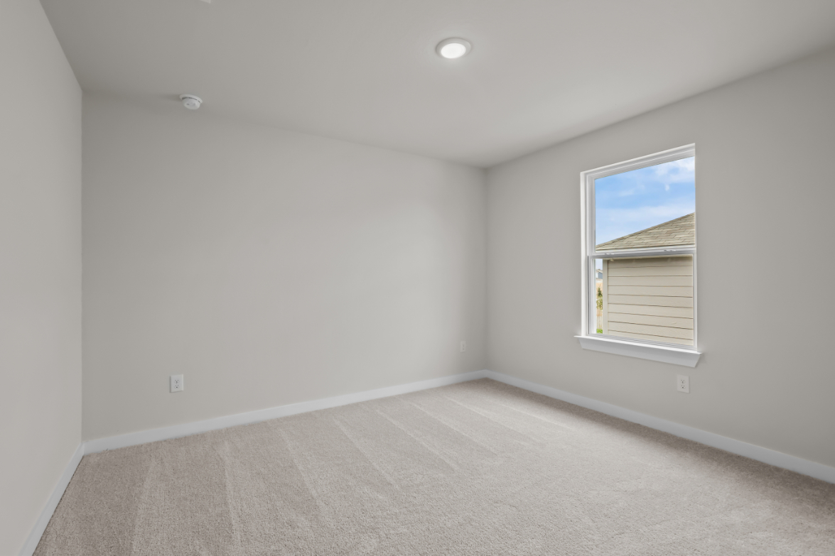 A room with a window and a carpet.