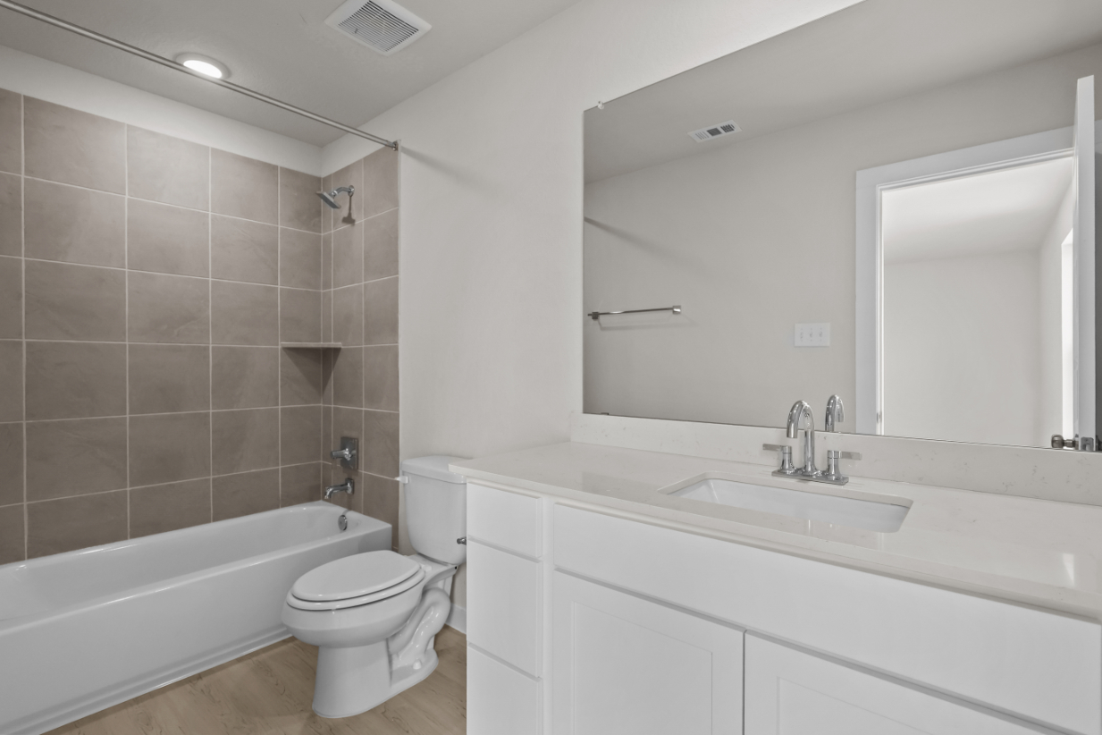 A bathroom with a tub sink and toilet.
