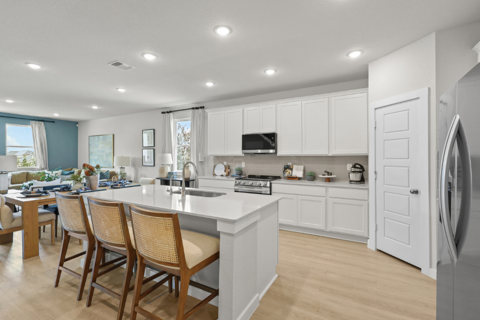 A kitchen with white cabinets.
