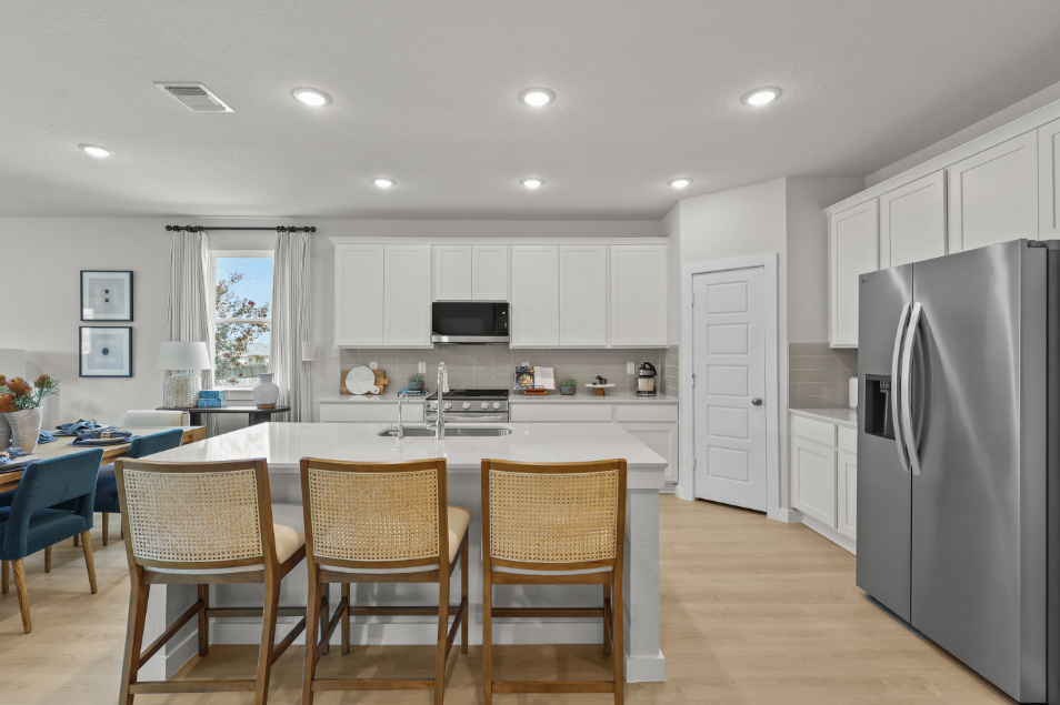 A kitchen with a table and chairs.