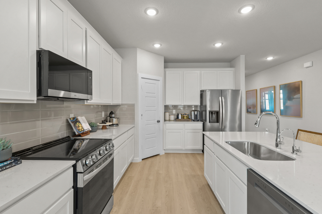 A kitchen with white cabinets.
