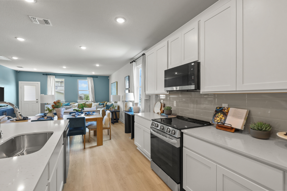 A kitchen with white cabinets.